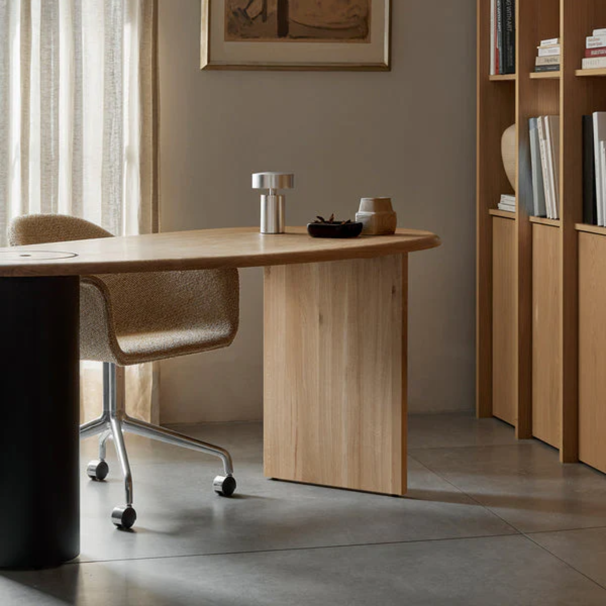 The brushed aluminum Column Portable Table Lamp from Audo Copenhagen in a home office on top of a desk.