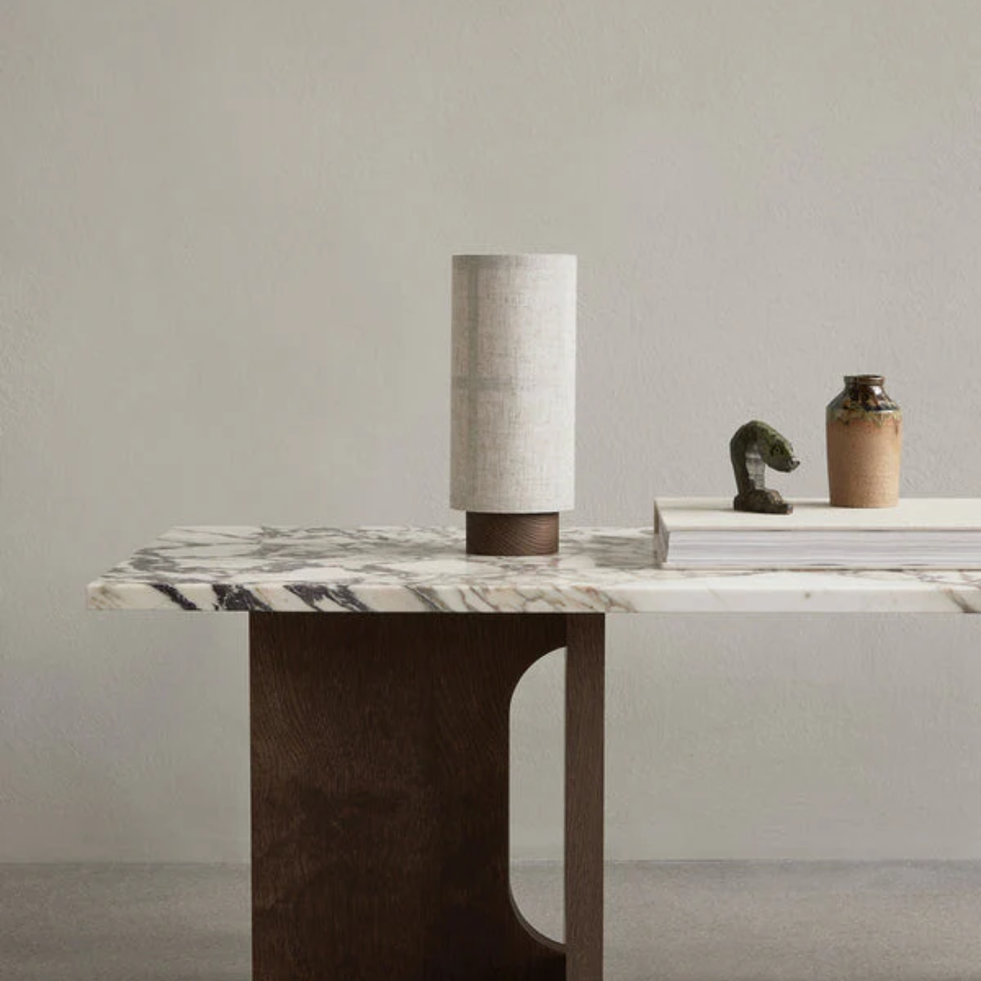 The Hashira Portable Table Lamp from Audo Copenhagen in a dining room on top of a marble and wood dining table.