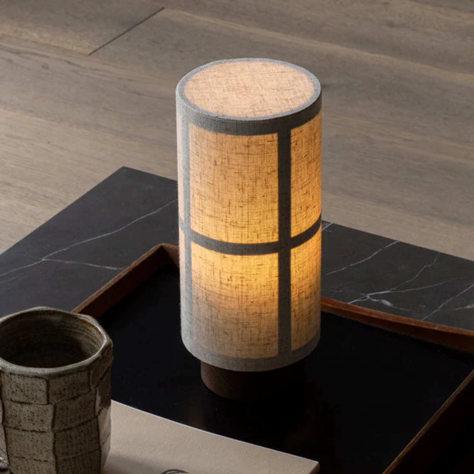 The Hashira Portable Table Lamp from Audo Copenhagen in a living room on a coffee table with a tray.