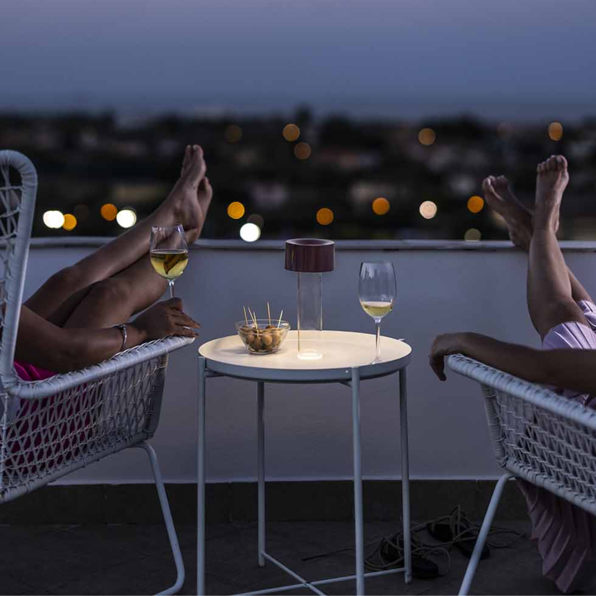 The burgundy Fleur Portable Table Lamp from Foscarini used in an outdoor lounge.