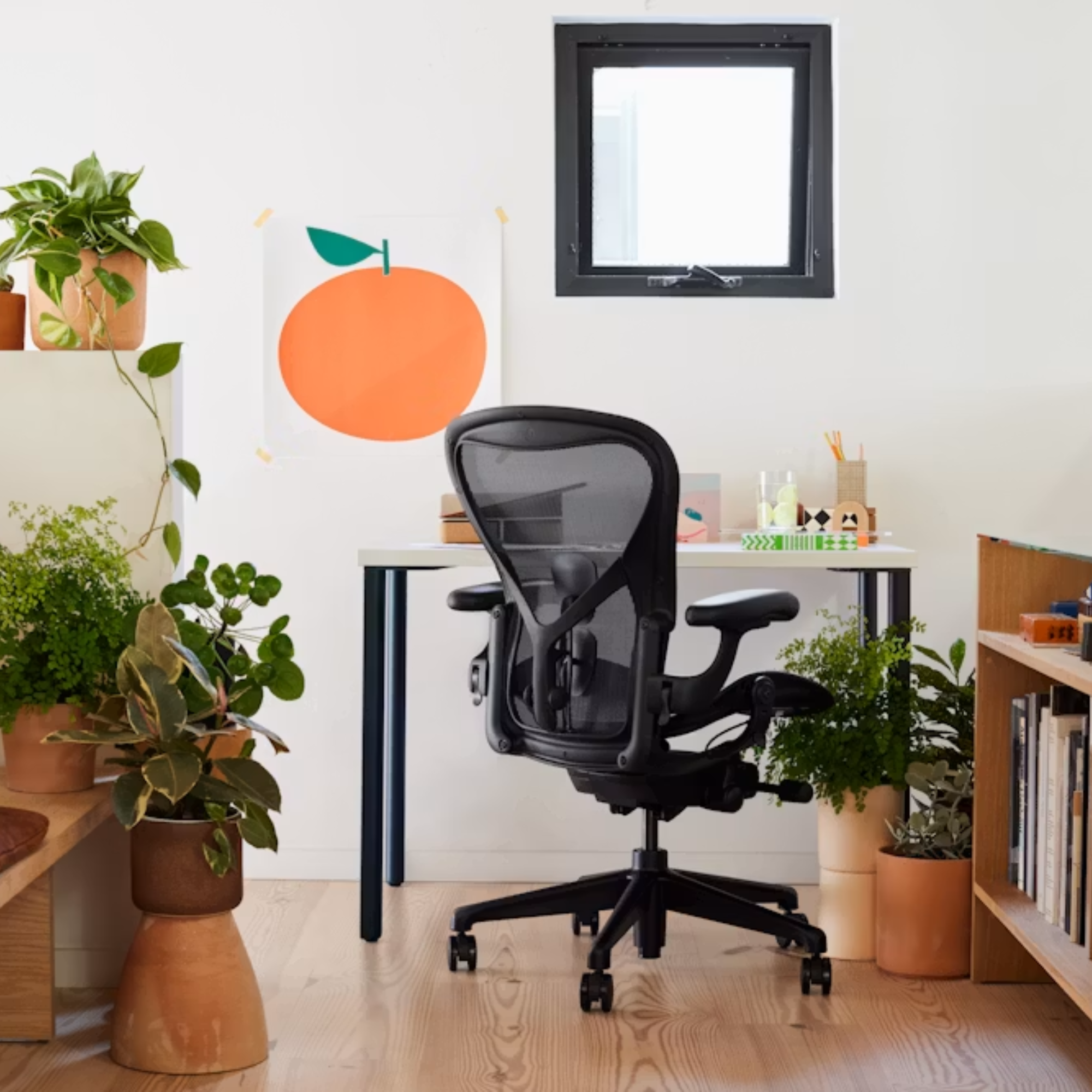 The Aeron Office Chair from Herman Miller shown in a home lounge, surronded by plants and decor.