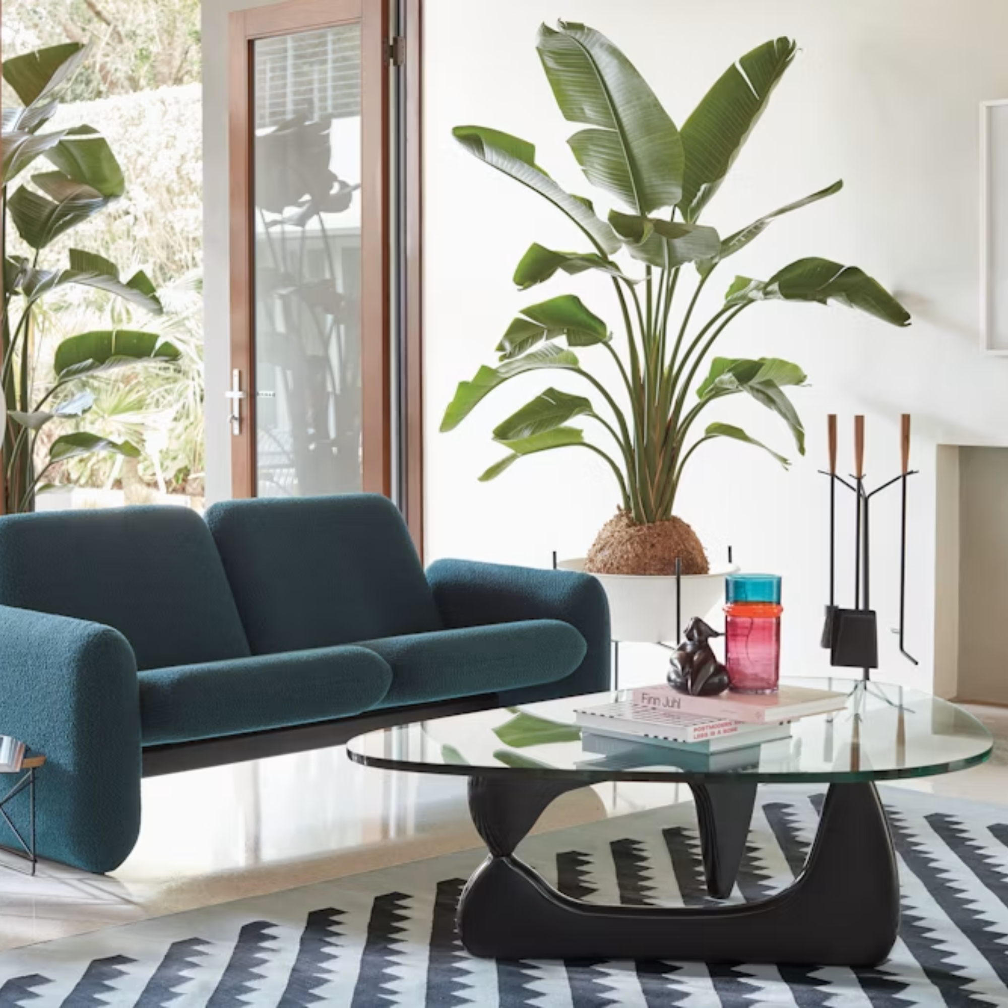 The black Noguchi Table from Herman Miller in a lounge in front of a blue Wilkes Sofa.
