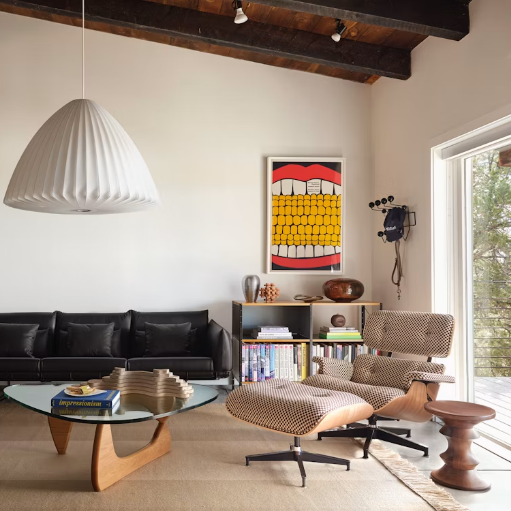 The white oak Noguchi Table from Herman Miller in a living room next to an Eames Lounge Chair and Ottoman.