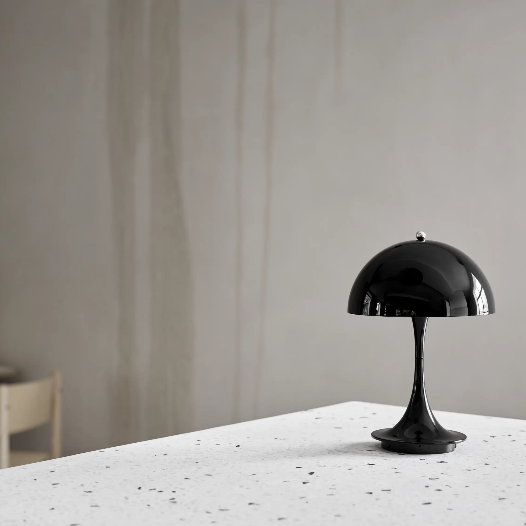 The black Panthella 160 Portable Lamp from Louis Poulsen in a dining room on top of a table.