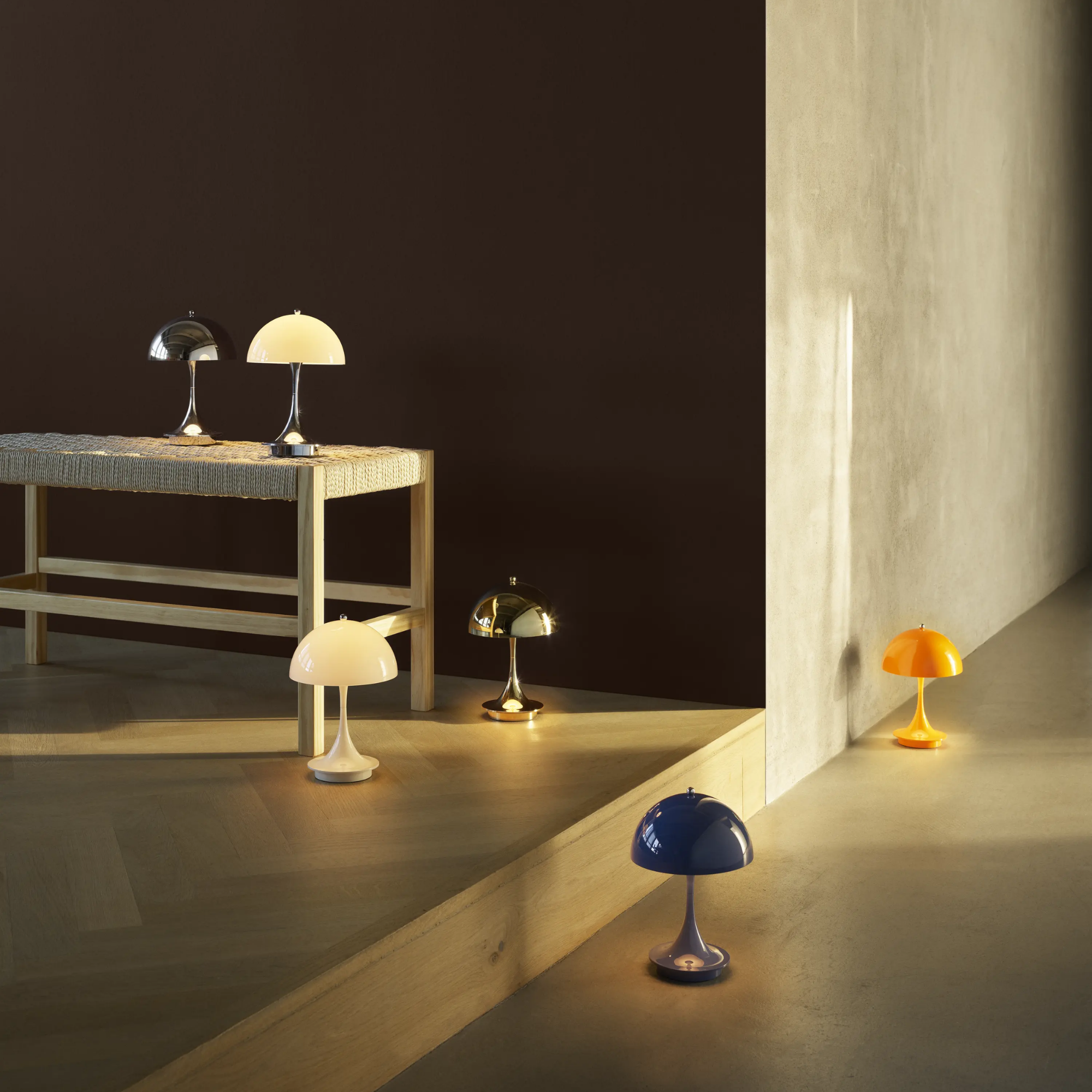The opal beige Panthella 160 Portable Lamp from Louis Poulsen in a lounge with various other color cordless lights.