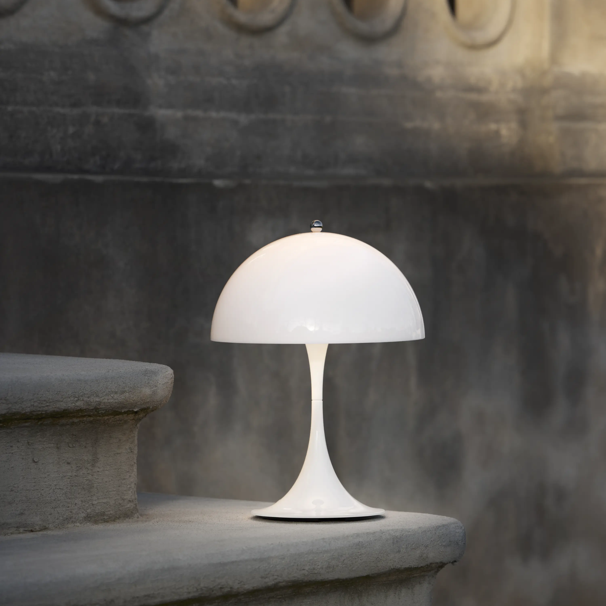 The opal Panthella 250 Portable Lamp from Louis Poulsen on an outdoor staircase.