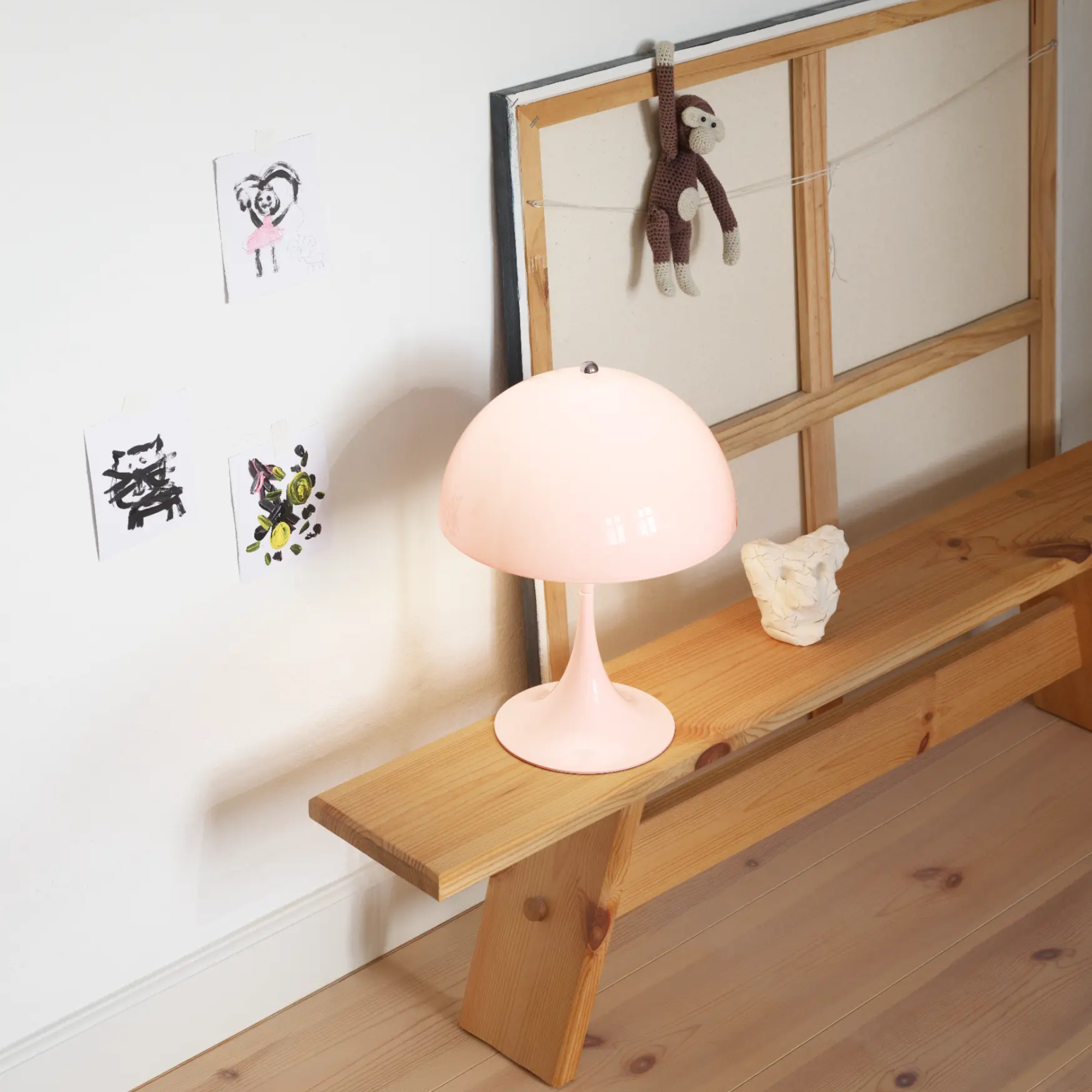 The pale rose opal Panthella 250 Portable Lamp from Louis Poulsen in a living room.