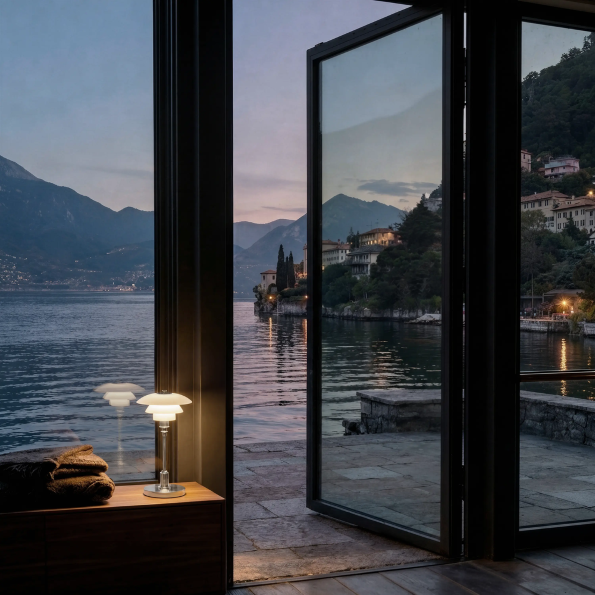 The chrome PH 1/1 Portable Lamp from Louis Poulsen used in the living room of a lake side home overlooking the lake.