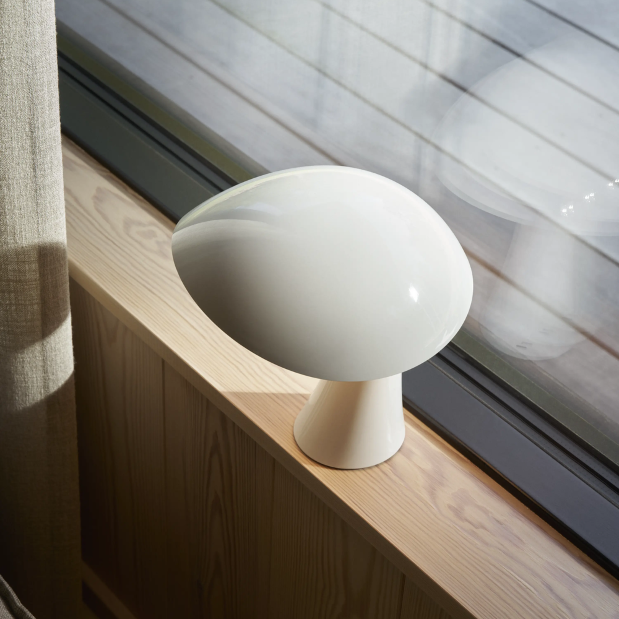 The cloud white Rumee 220 Portable Lamp from Louis Poulsen in a guest room.