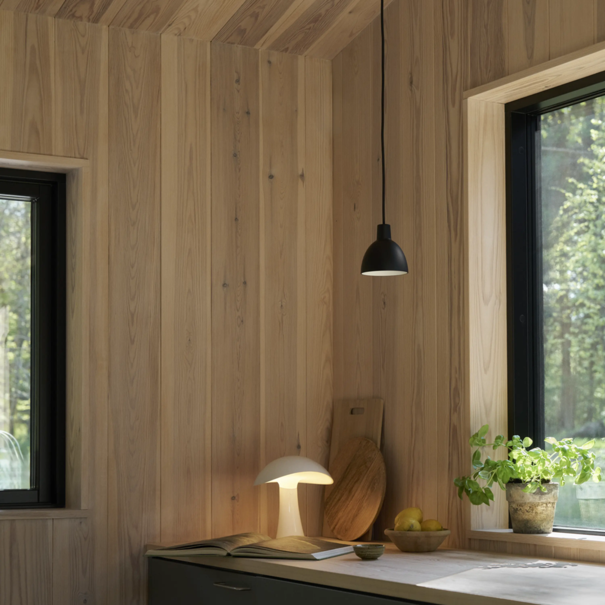 The cloud white Rumee 220 Portable Lamp from Louis Poulsen in a kitchen and dining setting.