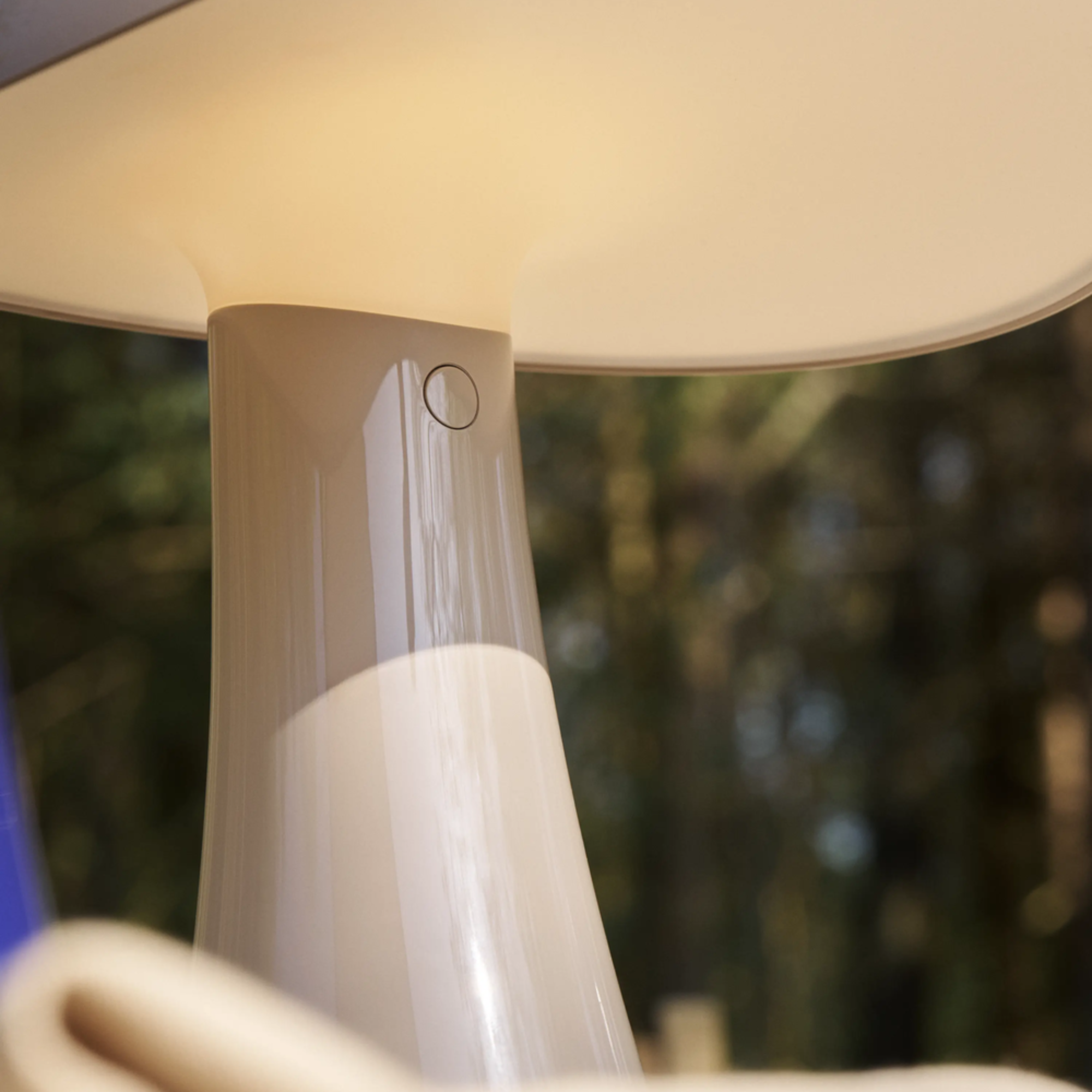 The earth gray Rumee 220 Portable Lamp from Louis Poulsen in an outdoor living space.