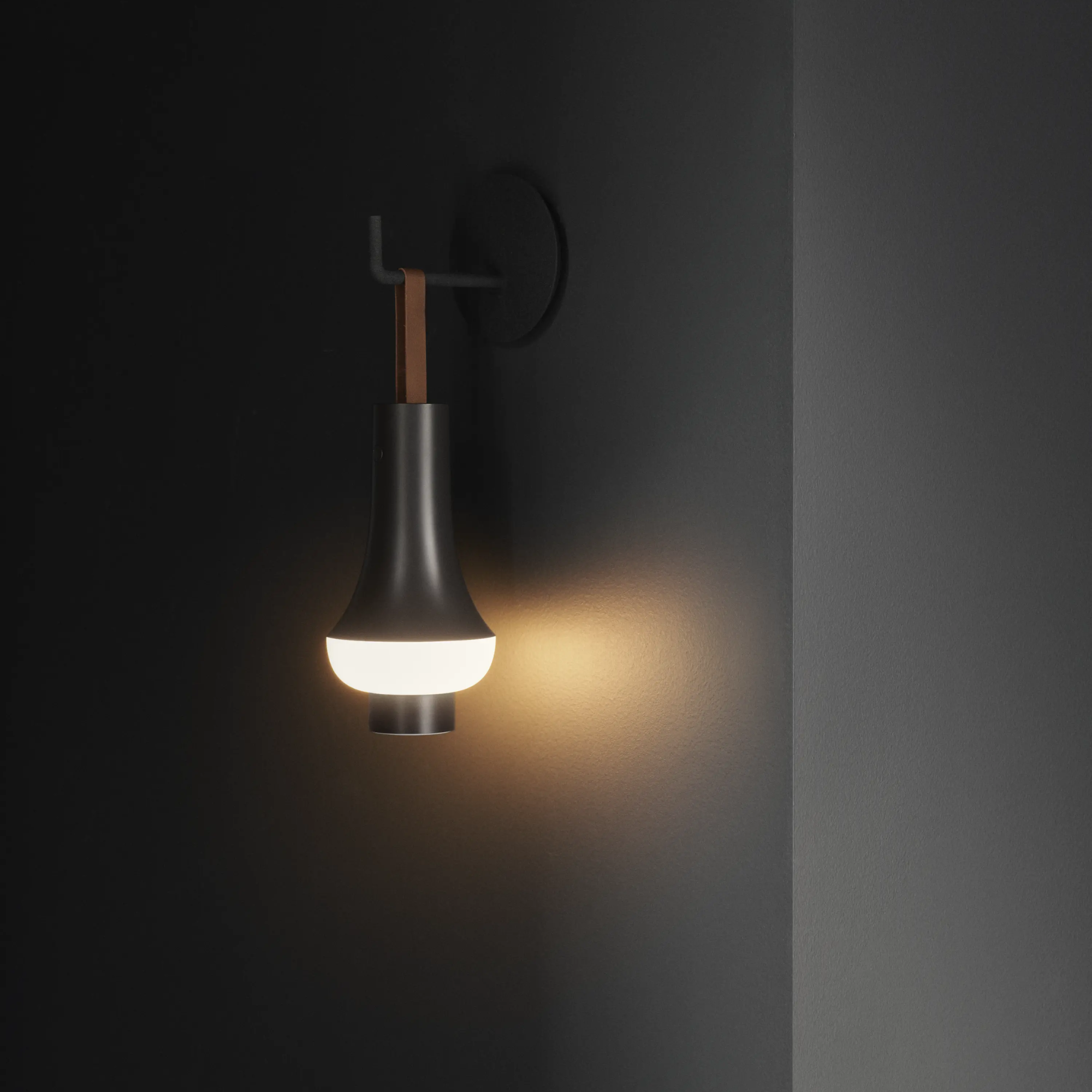 The dark brown Tomoshi Portable Lamp from Louis Poulsen used as a cordless wall sconce.