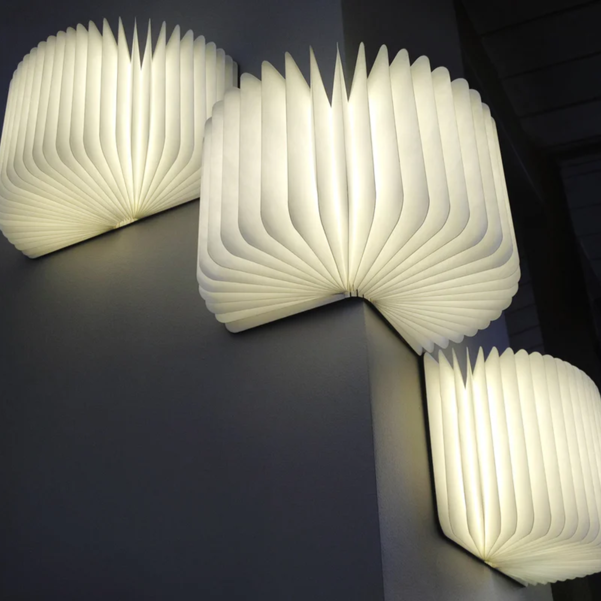 The Lito Classic Wood Cordless Book Lamp from Lumio against the wall in a lounge. all-groups