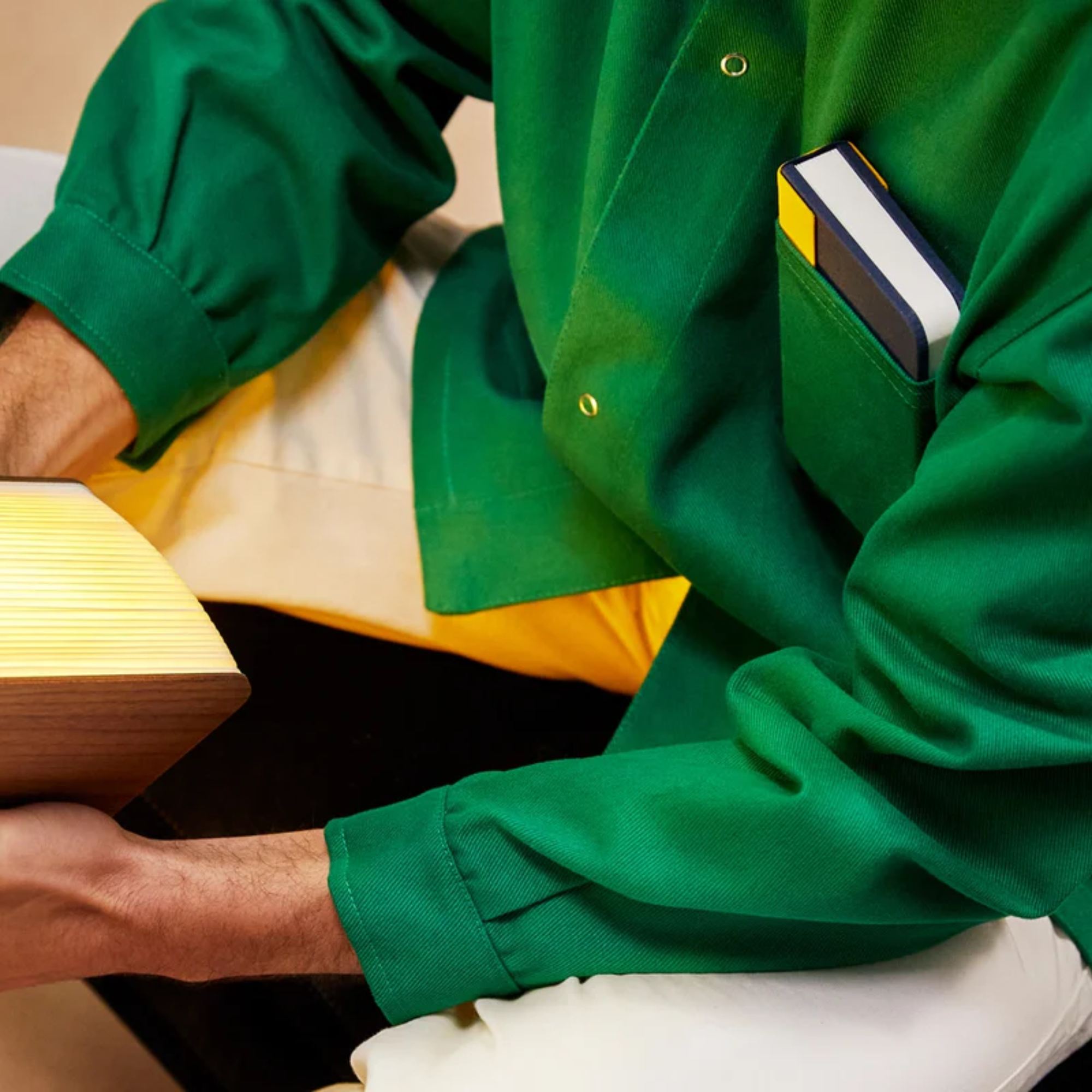 The Lito Mini Cordless Book Lamp from Lumio in a living space in a models shirt pocket. all-groups