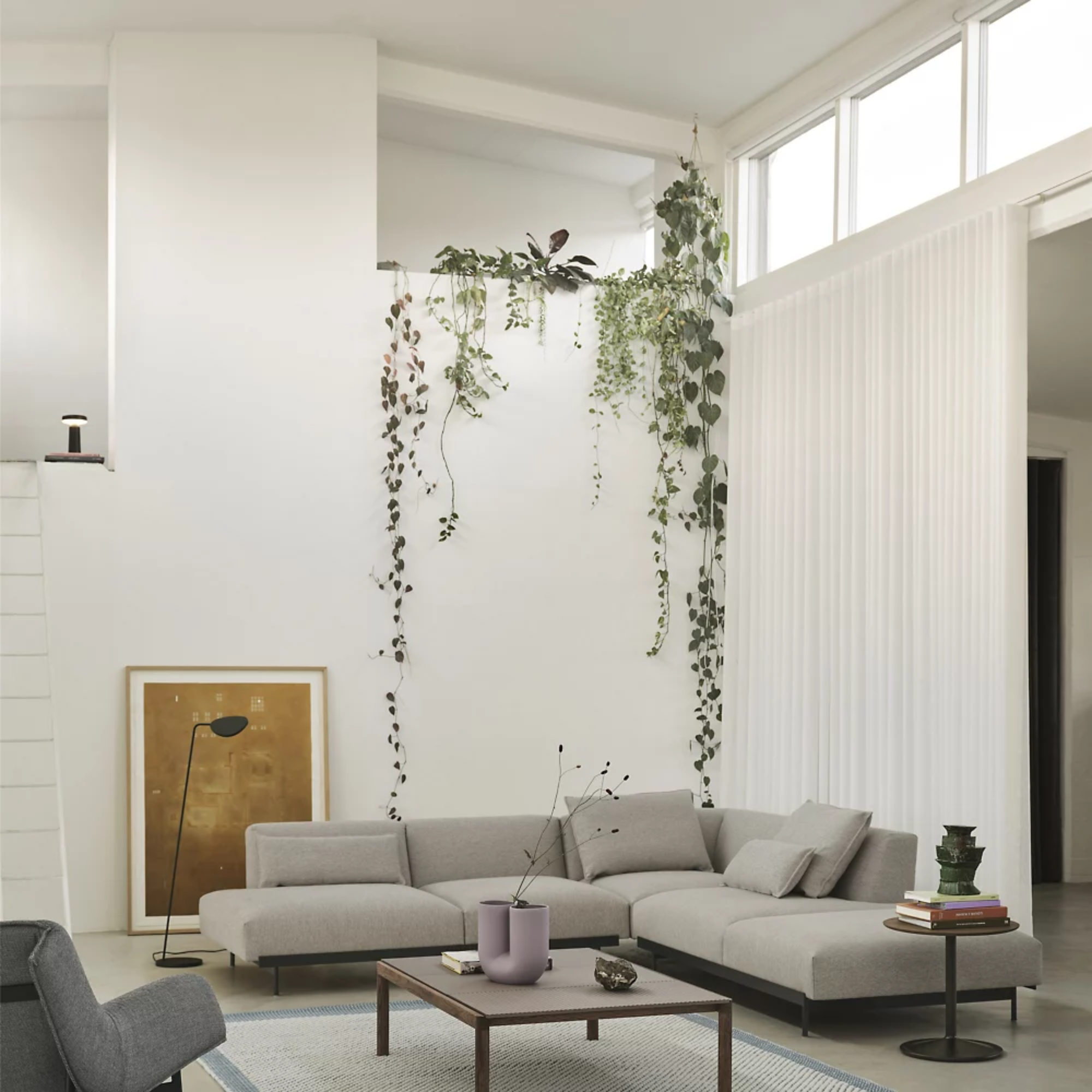 The black Ease Cordless Lamp from Muuto in a living area overlooking the sofa and other furniture.