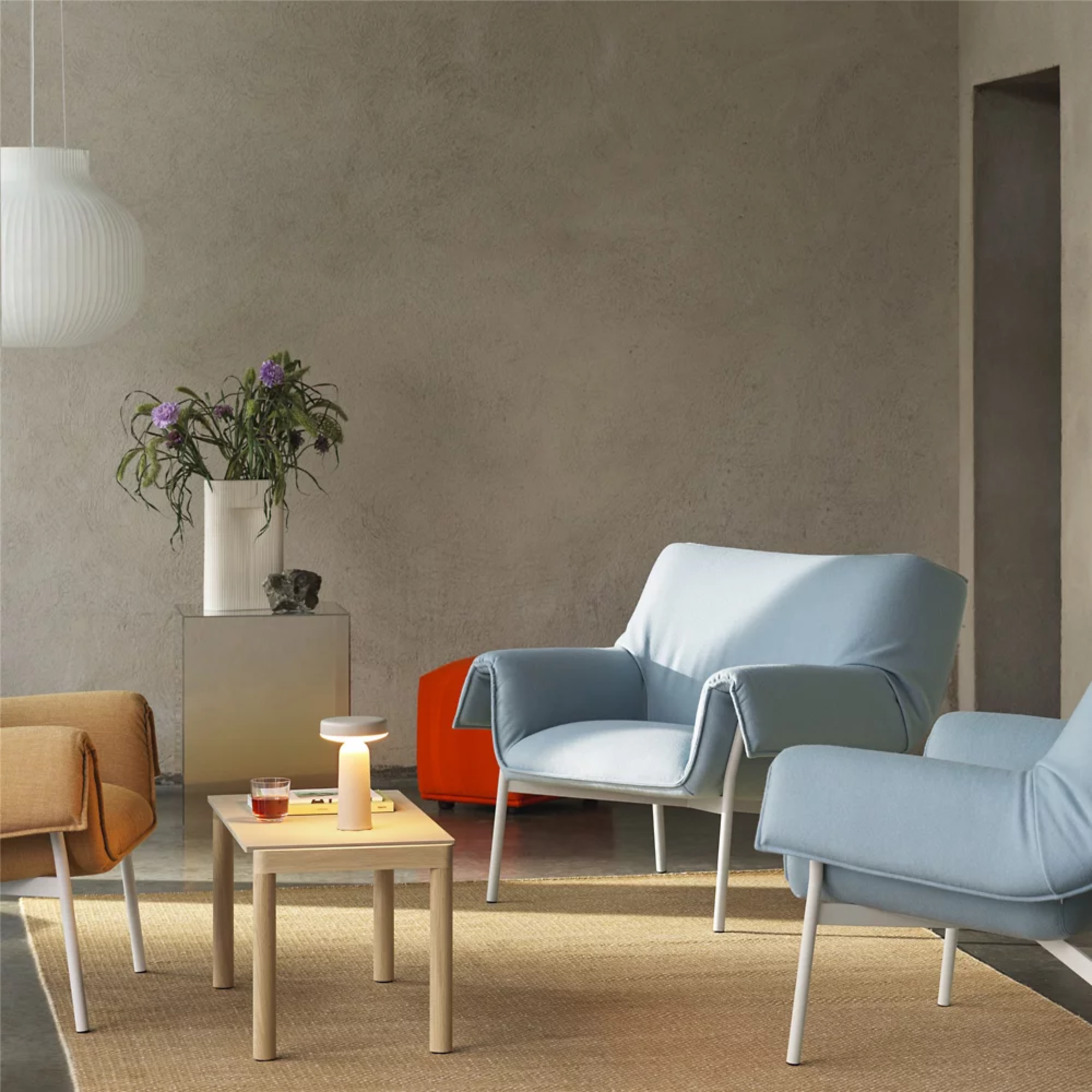 The gray Ease Cordless Lamp from Muuto in a family area on top of a coffee table.