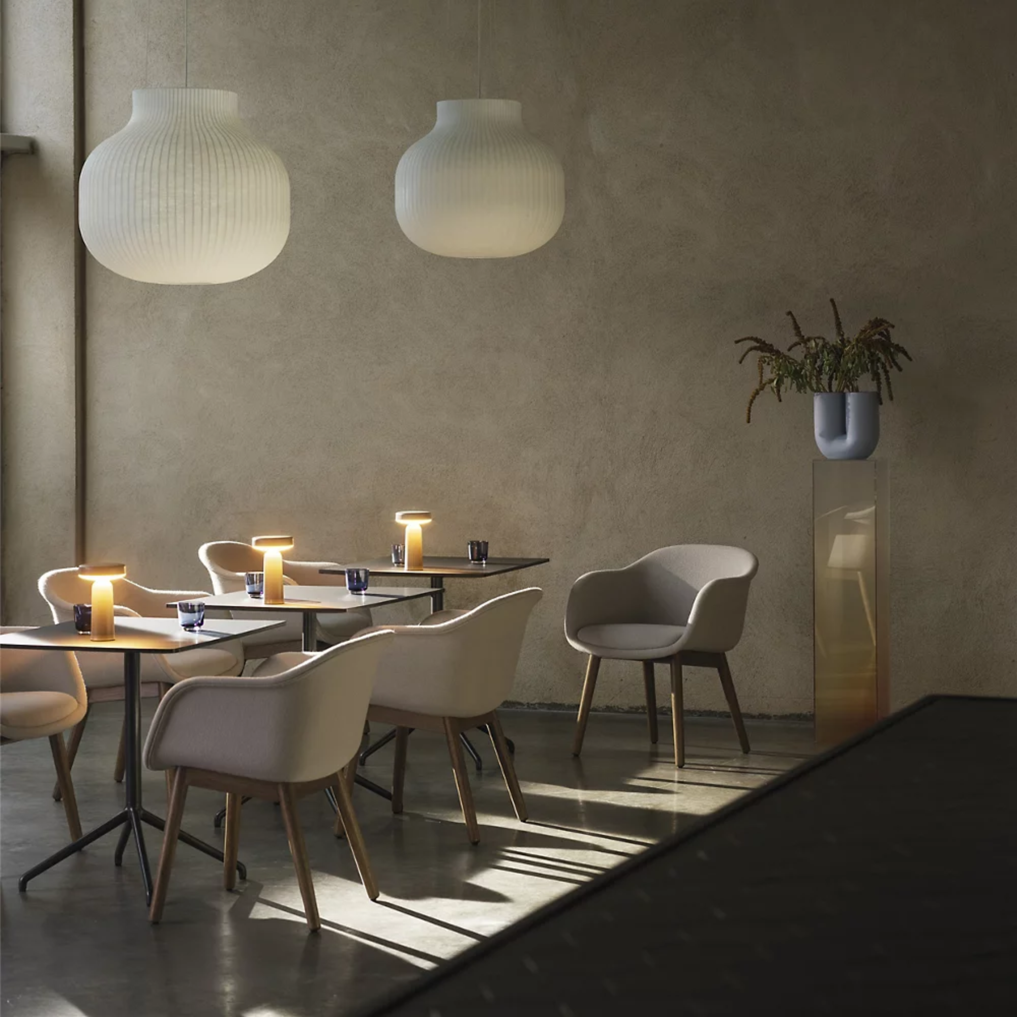 The gray Ease Cordless Lamp from Muuto used in an indoor restaurant.