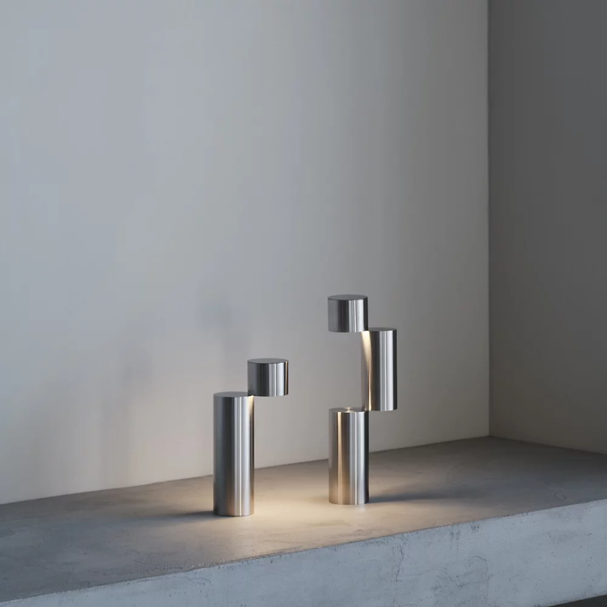 The MOMENT Cordless Lamp from Y.S.M in a living room showing two of the configurations on a stone surface. all-groups