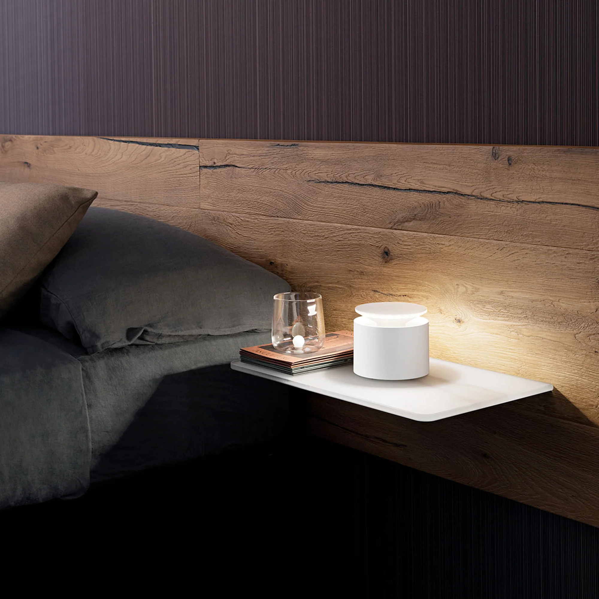 The white PushUp Pro Cordless Lamp from Zafferano in a guest bedroom on a floating bedside table.