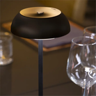 The black Float Cordless Lamp from Axolight on a dining table. all-groups