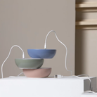 The blue, concrete green and mauve dust Float Cordless Lamp from Axolight charging in a home office. all-groups
