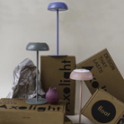 The blue, mauve dust and concrete green Float Cordless Lamp from Axolight in a living room. all-groups