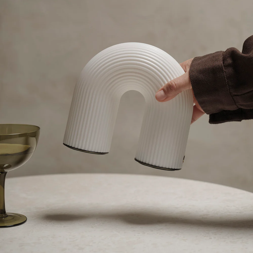 The Vuelta Portable Lamp from ferm LIVING in a living room.