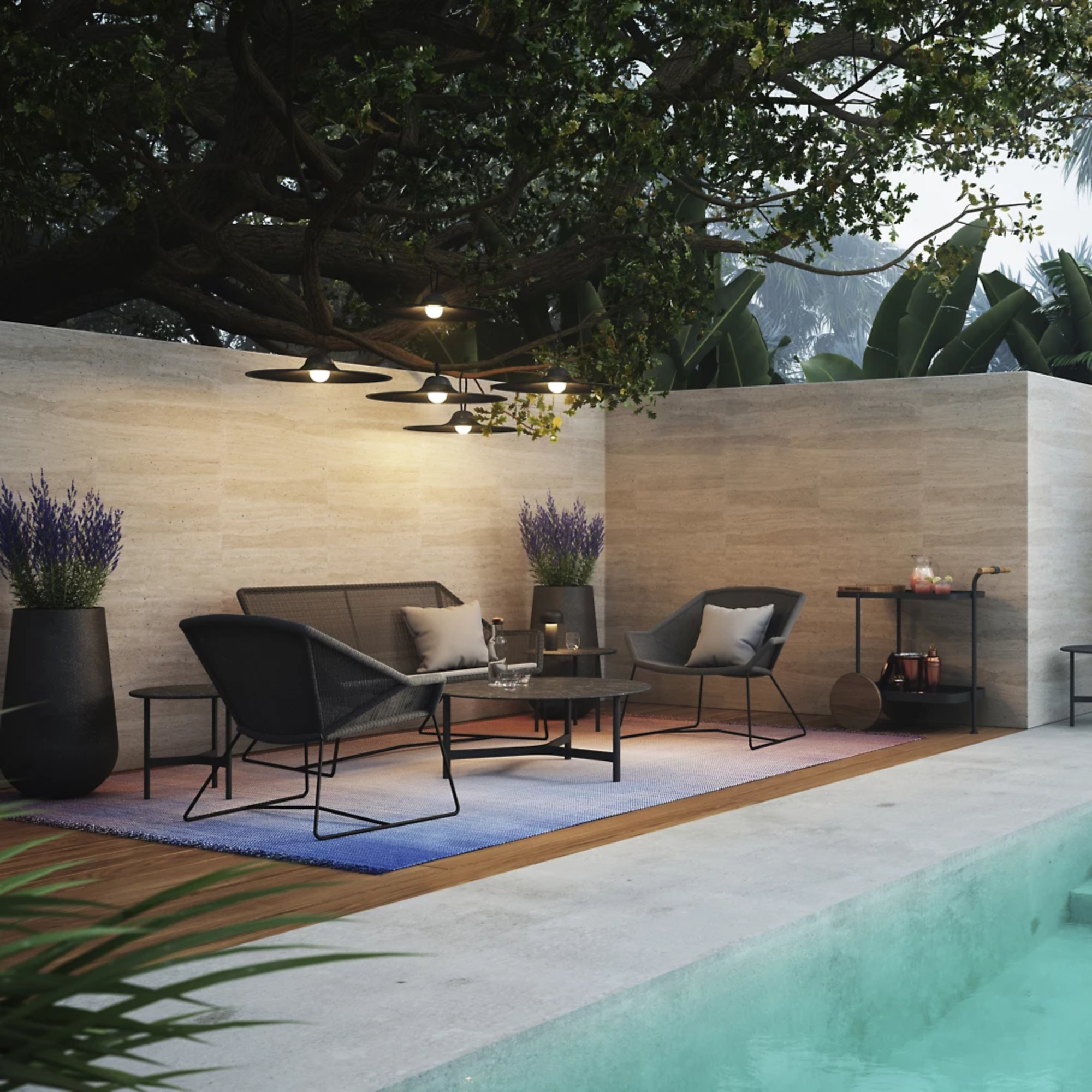 The matte black Bellhop Cordless Lamp from FLOS next to a pool in an outdoor living space.