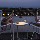 The burgundy Fleur Portable Table Lamp from Foscarini used in an outdoor lounge.