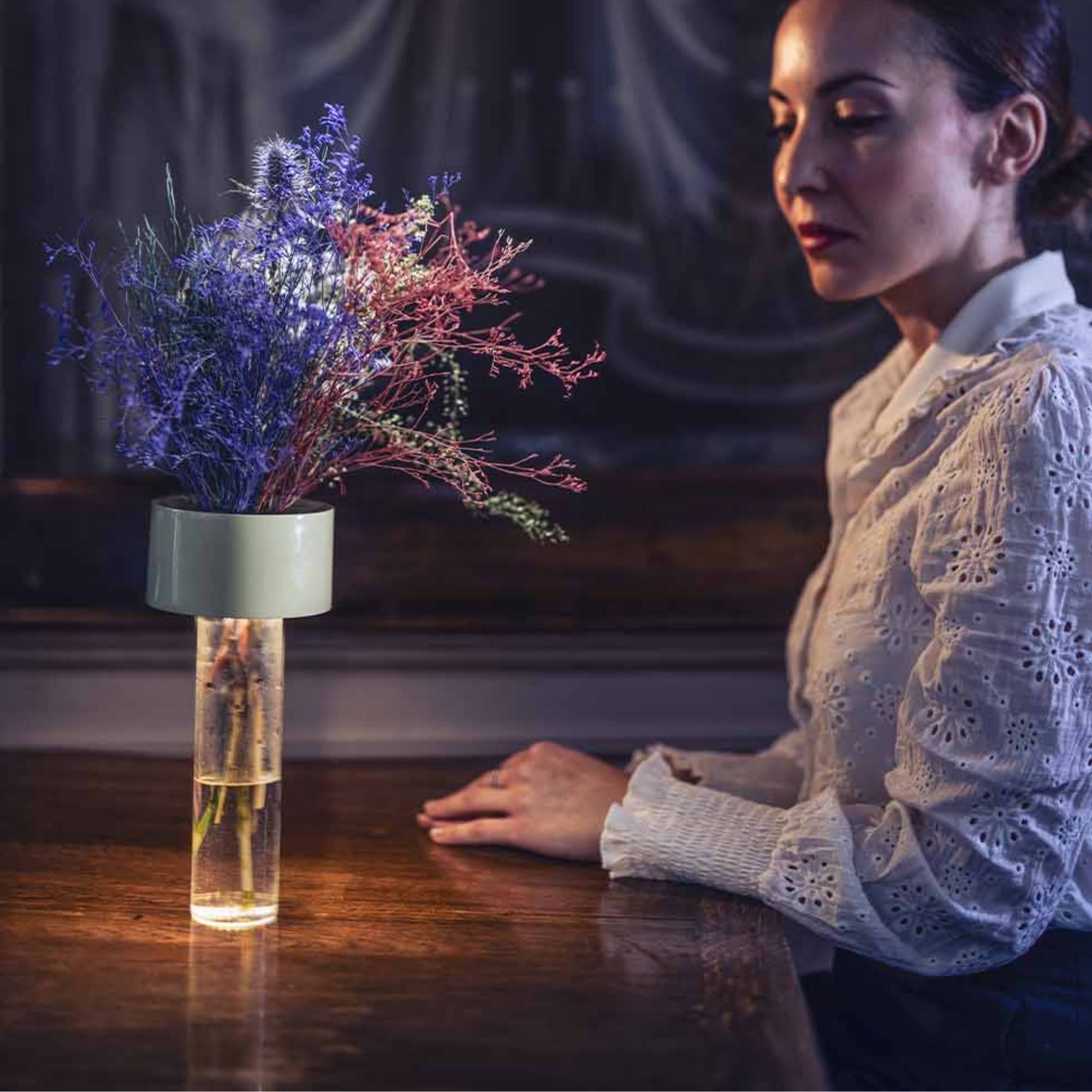 The sage green Fleur Portable Table Lamp from Foscarini on a table in a hotel.