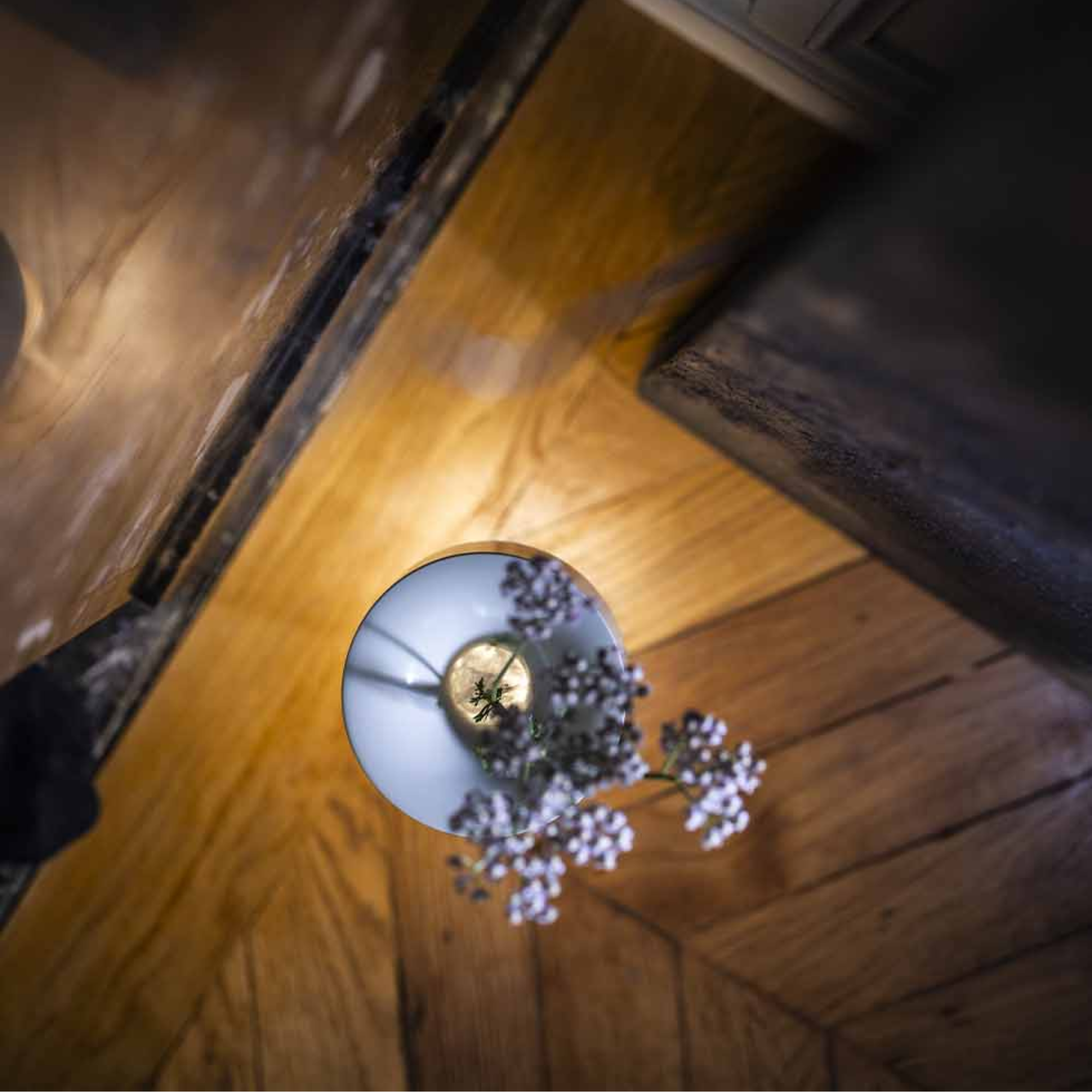 The white Fleur Portable Table Lamp from Foscarini on the floor in a family area.