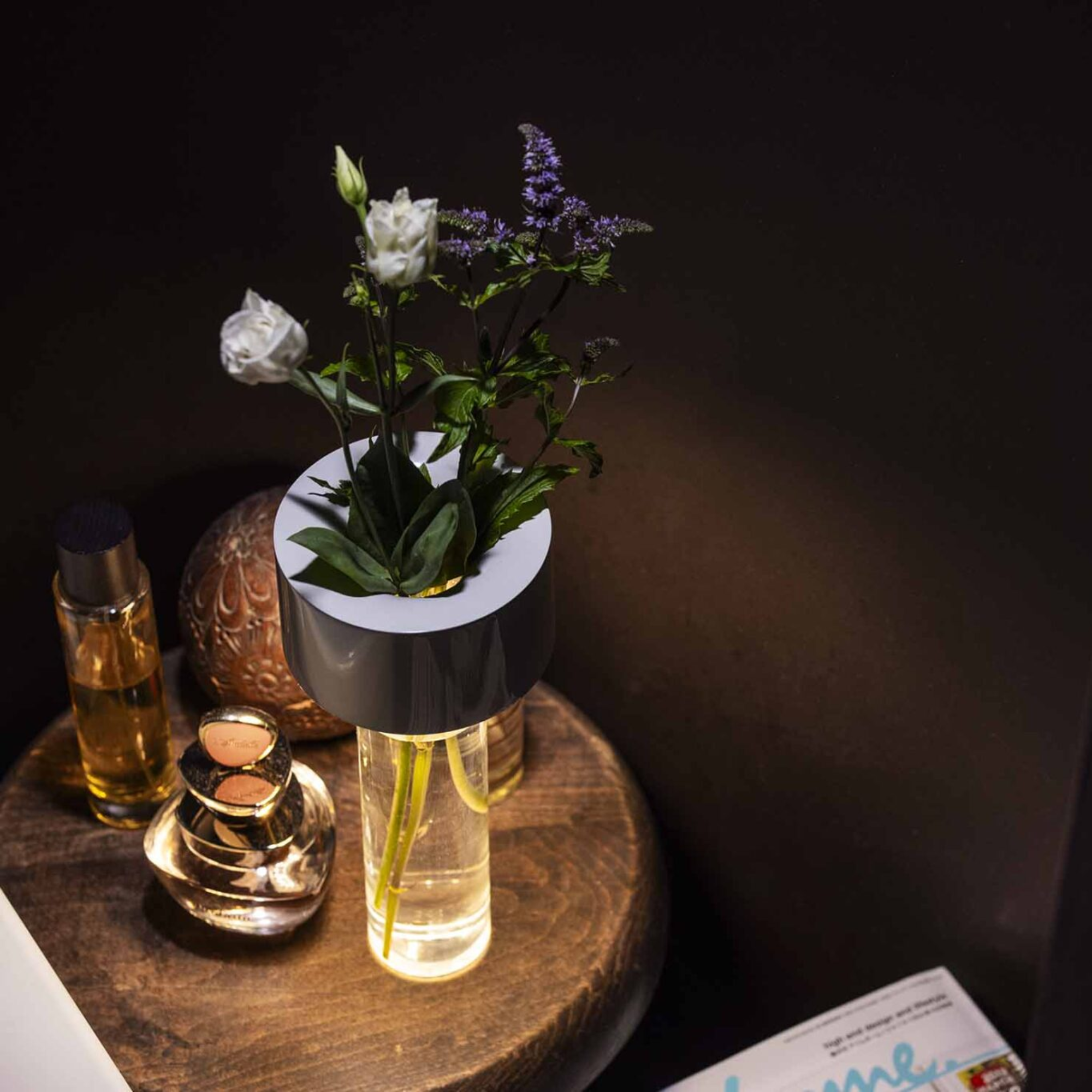 The white Fleur Portable Table Lamp from Foscarini in a living space on top of an end table.