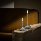 The aluminum Wick Cordless Lamp from Graypants in a living room on a piece of furniture.