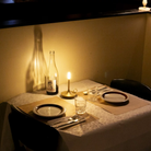 The Wick Pro Cordless Lamp from Graypants on a dining table with a bottle of wine.
