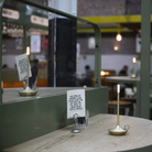The Wick Pro Cordless Lamp from Graypants in a cafe on top of table.