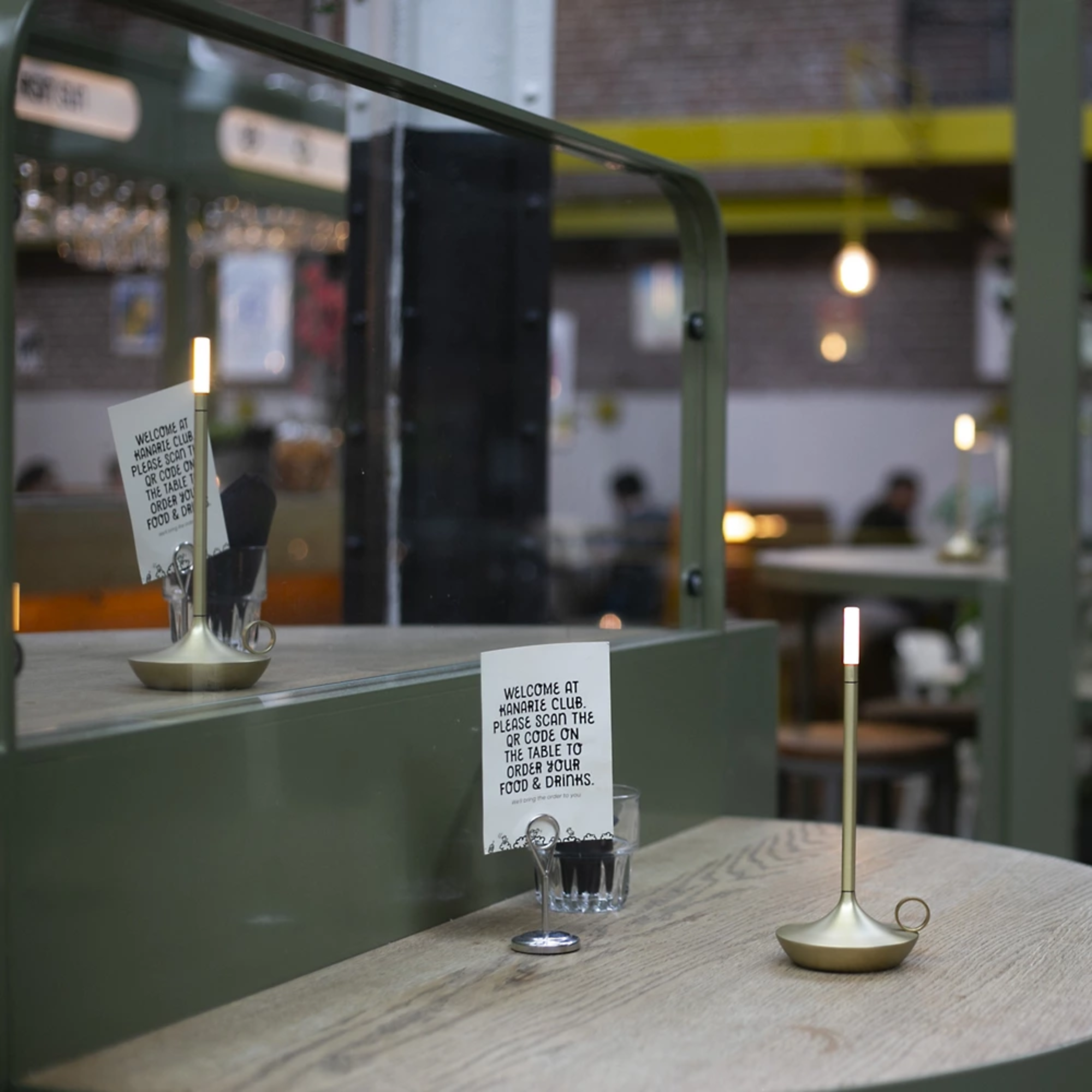 The Wick Pro Cordless Lamp from Graypants in a cafe on top of table.