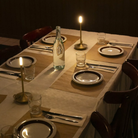 The Wick Pro Cordless Lamp from Graypants on top of a dining table set with glasses, plates and cutlery.