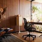 The Aeron Office Chair from Herman Miller shown in a business lounge in front of the Eames Lounge Chair and Ottoman.
