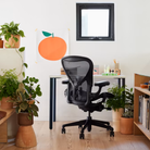 The Aeron Office Chair from Herman Miller shown in a home lounge, surronded by plants and decor.