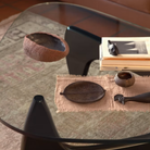 The black Noguchi Table from Herman Miller in a business space on top of a rug adorned with decor.