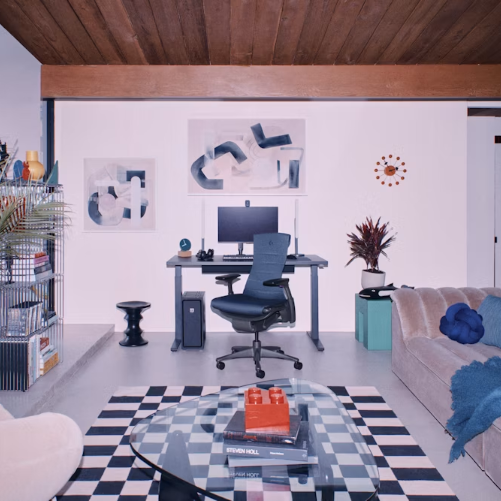 The black Noguchi Table from Herman Miller in a home gaming office near a Logitech Embody Gaming Chair.