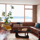The black Noguchi Table from Herman Miller in a meeting space between a lounge chair and sofa.