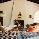 The white ash Noguchi Table from Herman Miller in a living space in front of an Eames Lounge Chair and Ottoman among other seating.
