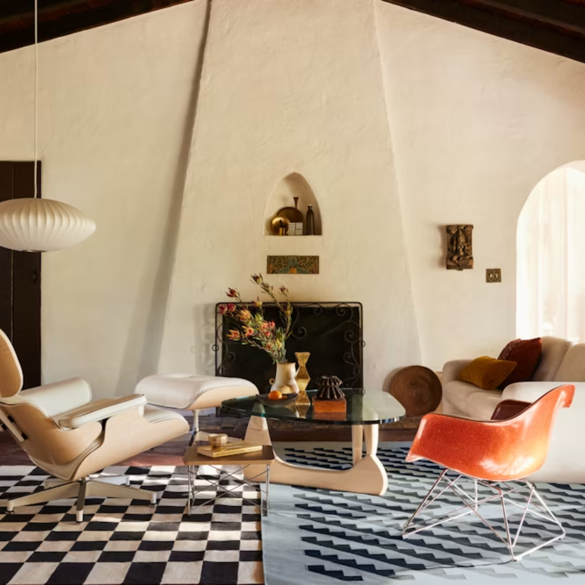 The white ash Noguchi Table from Herman Miller in a living space in front of an Eames Lounge Chair and Ottoman among other seating.