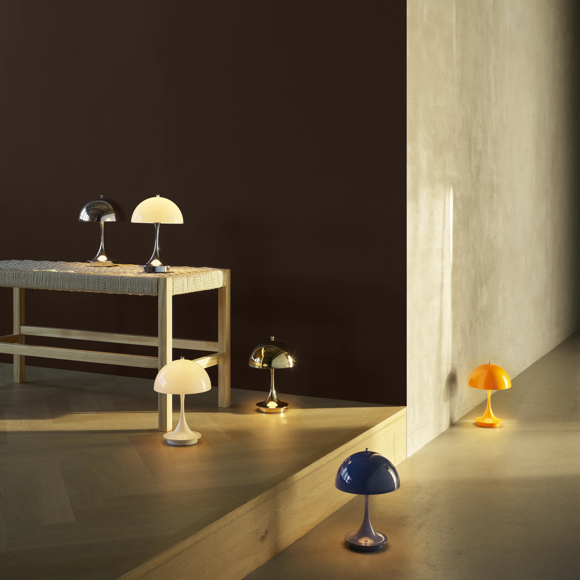The brass Panthella 160 Portable Lamp from Louis Poulsen in a living room with other cordless lighting.