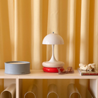 The opal Panthella 160 Portable Lamp from Louis Poulsen in a home office with other decor.