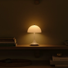 The opal Panthella 160 Portable Lamp from Louis Poulsen in a primary bedroom on a shelf.