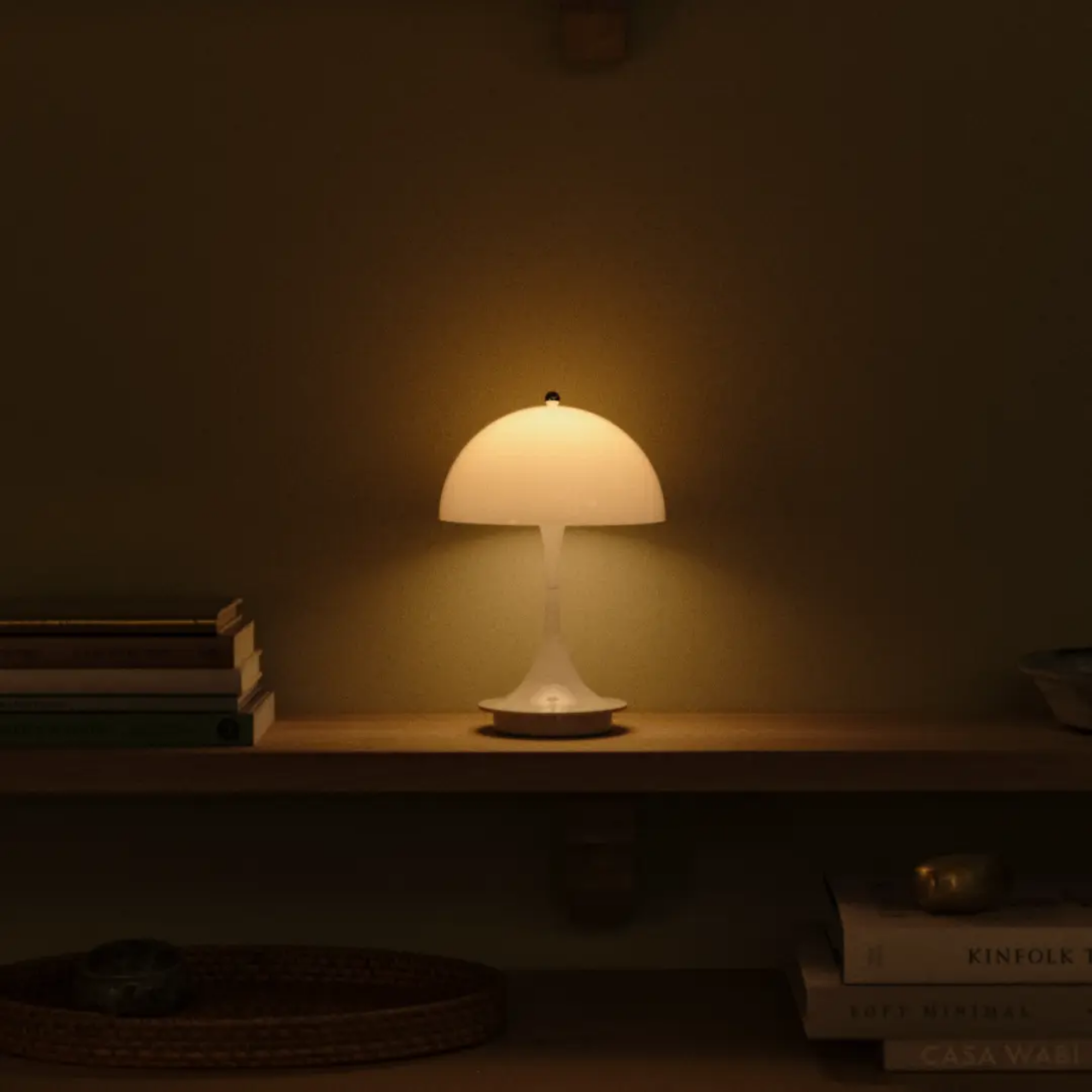 The opal Panthella 160 Portable Lamp from Louis Poulsen in a primary bedroom on a shelf.