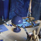 The opaque indigo Panthella 160 Portable Lamp from Louis Poulsen in an art studio.