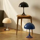 The black Panthella 250 Portable Lamp from Louis Poulsen in a living space with other rechargeable LED lights.